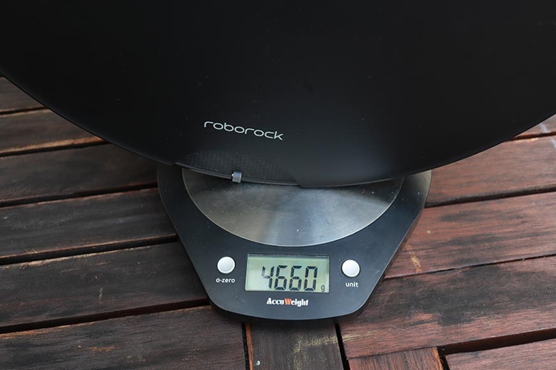 The Roborock S7 MaxV robot vacuum cleaner stands on a scale and is weighed.